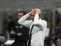 Trener w białej koszuli z granatowym krawatem, z rękami na głowie, przeżywa trudne chwile podczas meczu Juventus AC Milan.