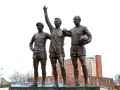Pomnik trzech legend Manchesteru United: Charlton, Law i Best. Ich postacie upamiętniają złote lata klubu.