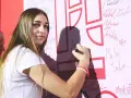 Julia Szeremeta pisze swoje imię na białej ścianie z czerwonymi elementami.