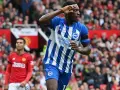 Piłkarz Brighton w niebiesko-białej koszulce świętuje bramkę przeciwko Man Utd. Casemiro z Manchesteru United w tle.