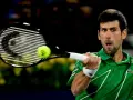 Novak Djoković, jeden z zwycięzców US Open, uderza piłkę rakietą.