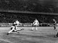 Bramkarz broni strzał w kluczowym momencie finału Ligi Mistrzów 2022. Stadion wypełniony kibicami.