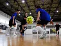 Graczki w hali sportowej ćwiczą zagrania, jedna z nich wykonuje pivot, podając piłkę nożną.