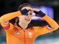 Femke Kok w pomarańczowym stroju TeamNL tworzy serce dłońmi, patrząc przez nie z uśmiechem.