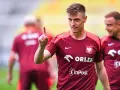 Krzysztof Piątek, w koszulce z orłem, pokazuje palcem do góry. Jego nowy krzysztof piątek transfer budzi nadzieję.