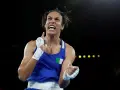 Imane Khelif, bokserka z Algierii, triumfuje po wygranej walce, uniesiona emocjami i dumą.