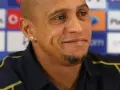Roberto Carlos, znany z prowadzenia drużyn, w ciemnej koszulce z żółtymi akcentami, na tle z logo PlayStation.