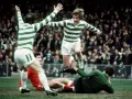 Futboliści z Glasgow w zielono-białych pasach świętują zwycięstwo, jeden z nich przeskakuje nad leżącym przeciwnikiem.