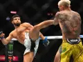 Waga półśrednia UFC: zawodnik wykonuje wysokie kopnięcie, jego przeciwnik z tatuażem lwa na plecach blokuje cios.