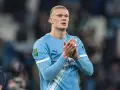 Erling Haaland w błękitnej koszulce Manchesteru City, z dłońmi złożonymi w geście uznania.