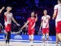 Siatkarze w biało-czerwonych strojach świętują zwycięstwo. Jeden z nich, z numerem 3, pokazuje kciuk w górę. To z pewnością emocjonujące mecze dla kibiców, którzy wspierają drużynę.