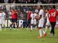 Piłkarze PSG i Lille świętują po meczu. Jeden z zawodników Lille klęczy na boisku.