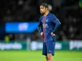 Piłkarz PSG w meczu z Le Havre AC, z rękami na biodrach, wpatrzony w dal.