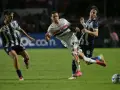 Piłkarze walczą o piłkę na boisku, jeden z nich w białej koszulce z logo São Paulo FC, walcząc o wysokie rankingi.