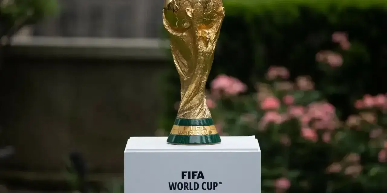 Złote trofeum FIFA World Cup na białym postumencie, symbol marzeń o zwycięstwie na **mistrzostwach świata 2030**.