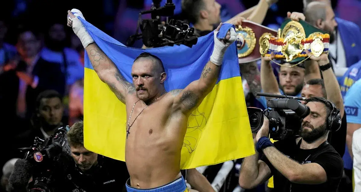 Oleksandr Usyk, po zwycięstwie nad Anthonym Joshuą, triumfalnie unosi flagę Ukrainy.