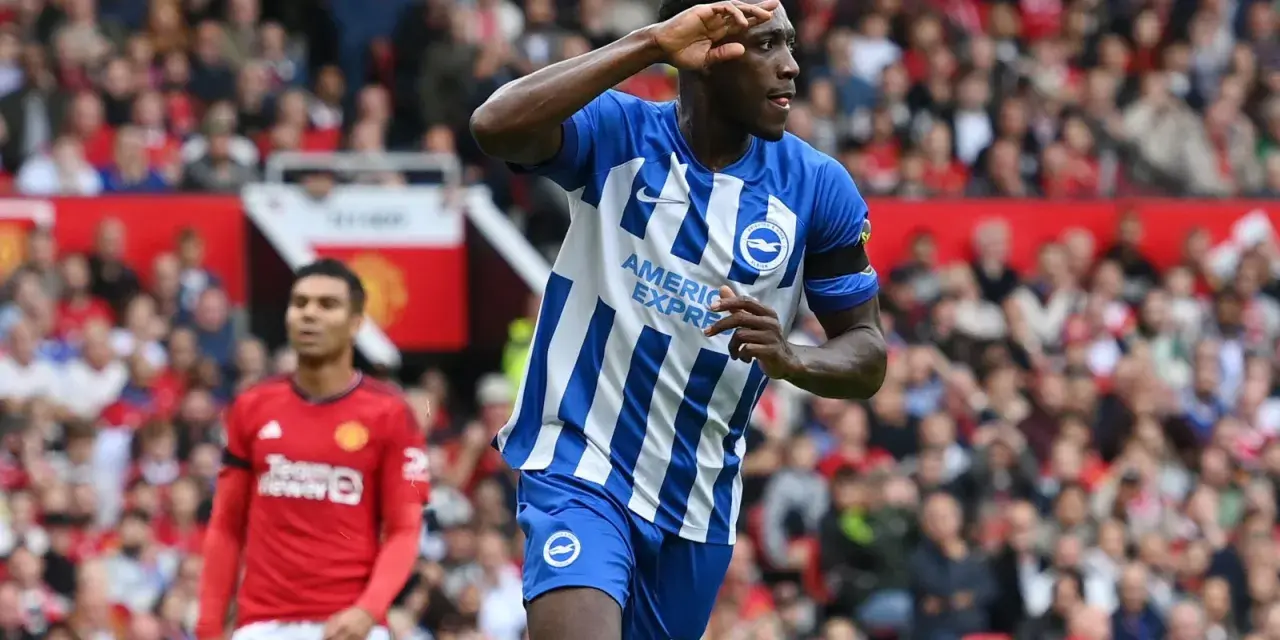 Piłkarz Brighton w niebiesko-białej koszulce świętuje bramkę przeciwko Man Utd. Casemiro z Manchesteru United w tle.