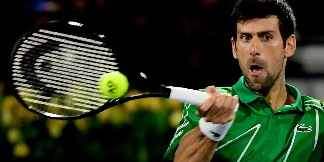 Novak Djoković, jeden z zwycięzców US Open, uderza piłkę rakietą.