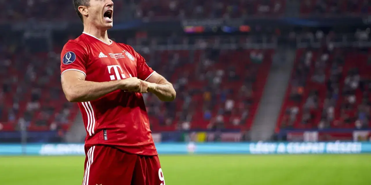 Robert Lewandowski w czerwonej koszulce Bayernu świętuje bramkę. Krótka biografia tego piłkarza to historia sukcesów.