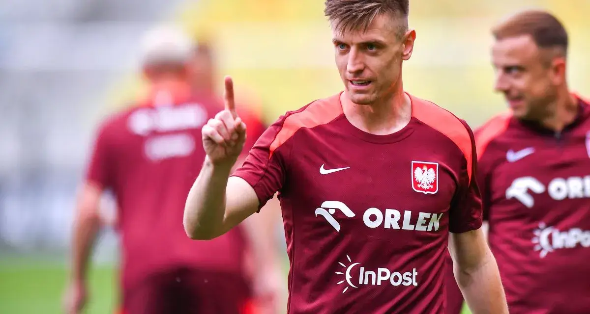 Krzysztof Piątek, w koszulce z orłem, pokazuje palcem do góry. Jego nowy krzysztof piątek transfer budzi nadzieję.