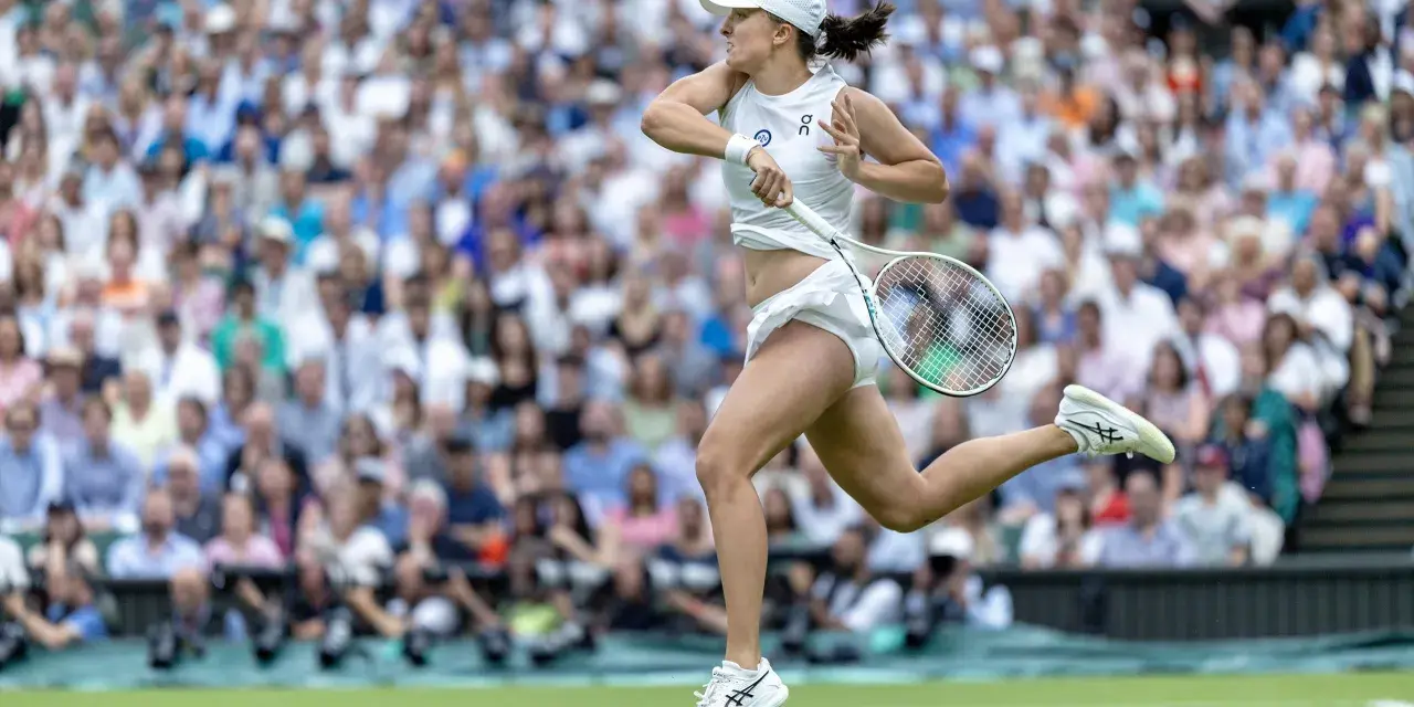 Tenisistka w akcji na korcie podczas WTA Berlin. Dynamiczny ruch, rakieta w dłoni, tłum kibiców na trybunach.