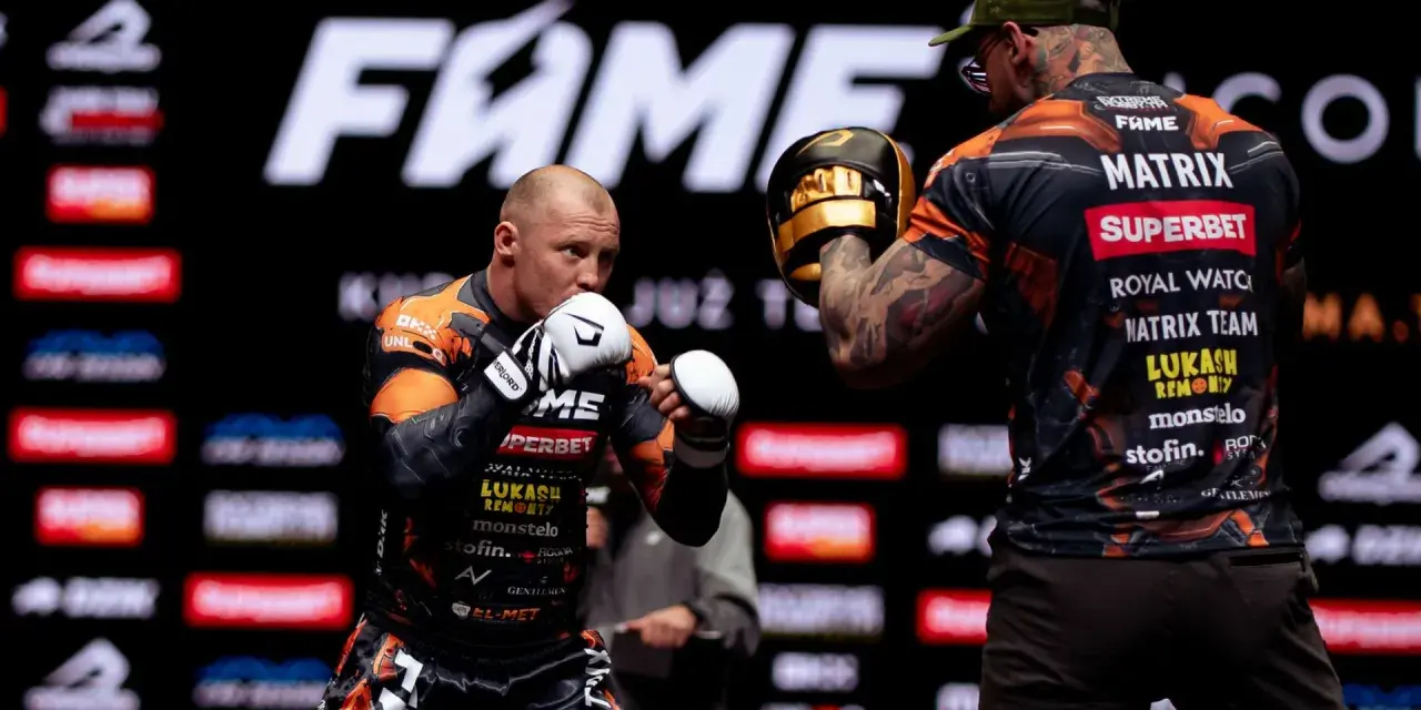 Bokserzy na treningu przed galą FAME MMA. Jeden z nich w rękawicach, drugi z łapami treningowymi.