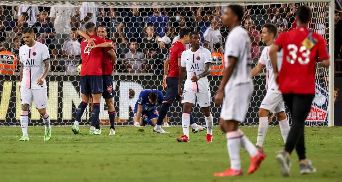 Piłkarze PSG i Lille świętują po meczu. Jeden z zawodników Lille klęczy na boisku.