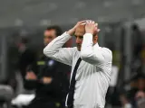 Trener w białej koszuli z granatowym krawatem, z rękami na głowie, przeżywa trudne chwile podczas meczu Juventus AC Milan.