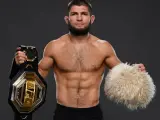 Khabib Nurmagomedov, jeden z najlepsi zawodnicy mma w historii, prezentuje pas UFC i tradycyjną czapkę.