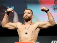 Jan Błachowicz, wojownik kategorii lekkiej UFC, napina bicepsy.