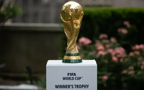 Złote trofeum FIFA World Cup na białym postumencie, symbol marzeń o zwycięstwie na **mistrzostwach świata 2030**.