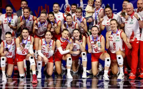 Drużyna siatkówki kobiet Polska świętuje sukces w Lidze Narodów. Zawodniczki z medalami na szyjach i uśmiechami na twarzach.