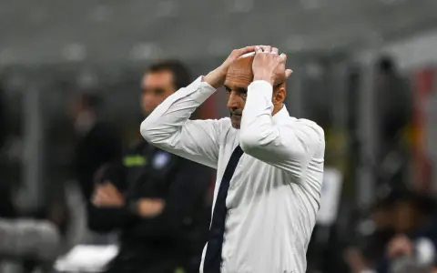 Trener w białej koszuli z granatowym krawatem, z rękami na głowie, przeżywa trudne chwile podczas meczu Juventus AC Milan.