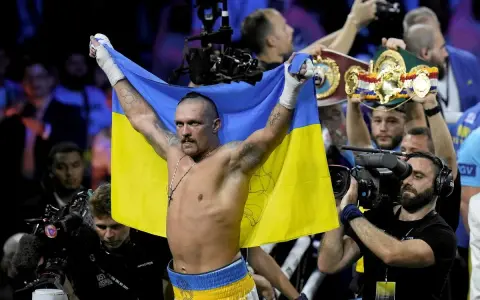 Oleksandr Usyk, po zwycięstwie nad Anthonym Joshuą, triumfalnie unosi flagę Ukrainy.