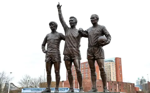 Pomnik trzech legend Manchesteru United: Charlton, Law i Best. Ich postacie upamiętniają złote lata klubu.