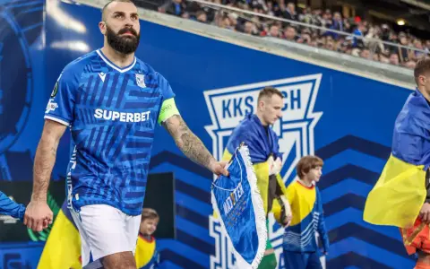 Piłkarz Lecha Poznań z flagą Szachtara na ręku, podczas meczu.