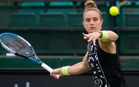 Maria Sakkari w akcji, uderza piłkę rakietą. Skupiona na grze, gotowa do zwycięstwa.