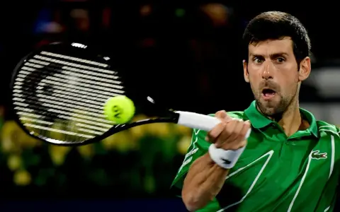 Novak Djoković, jeden z zwycięzców US Open, uderza piłkę rakietą.