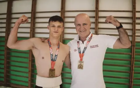 Dwóch zapaśników sumo z medalami, młody zawodnik w tradycyjnym stroju i trener. Prawdopodobnie świętują rekord Polski suma.