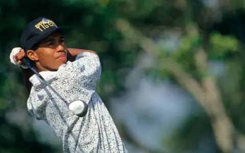 Młody Tiger Woods, którego majątek budował od lat, wykonuje zamach kijem golfowym.