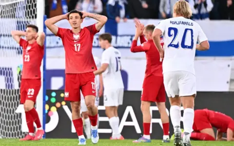 Piłkarze w czerwonych strojach, w tym jeden z numerem 17, wyrażają frustrację. Polska przegrywa mecz.