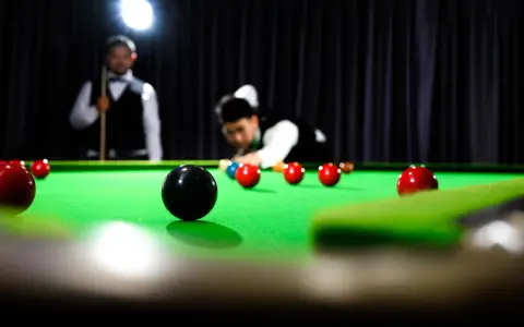 Gracze w skupieniu rozgrywają mecz snookera, zbliżając się do zwycięstwa w snooker mistrzostwa świata.