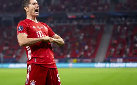 Robert Lewandowski w czerwonej koszulce Bayernu świętuje bramkę. Krótka biografia tego piłkarza to historia sukcesów.