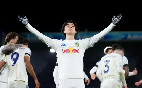 Piłkarz Leeds świętuje zwycięstwo nad Liverpoolem, wznosząc ręce ku górze.