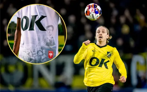 Piłkarz NAC Breda w żółtej koszulce z logo OK. W tle widać fragment koszulki z historycznymi zdjęciami i godłem Polski.