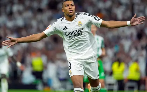 Piłkarz Realu Madryt w białej koszulce z numerem 9, radośnie świętujący bramkę. Spekulacje o la liga transfery z jego udziałem trwają.
