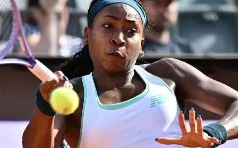 Coco Gauff w akcji, skupiona na odbiciu piłki podczas meczu.