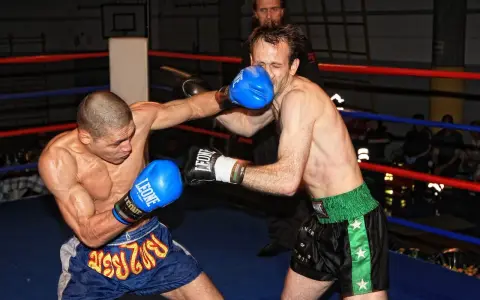 Dwóch zawodników wagi średniej UFC walczy w ringu. Jeden z nich wyprowadza cios, drugi blokuje.