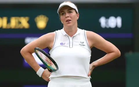 Anastasija Pawluczenkowa z rakietą, w białej koszulce Wimbledonu, zamyślona na korcie.