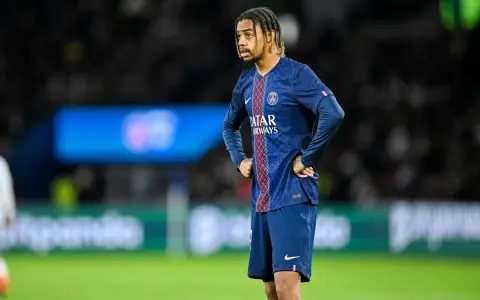 Piłkarz PSG w meczu z Le Havre AC, z rękami na biodrach, wpatrzony w dal.